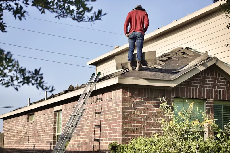 Professional roofer working on a residential roof in Wolfe City